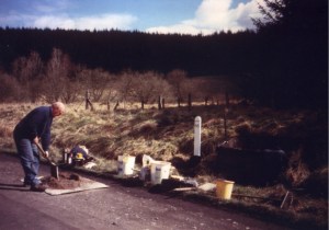 Len Ashton mixes concrete for setting milepost 66 in place just south of Riccarton Junction